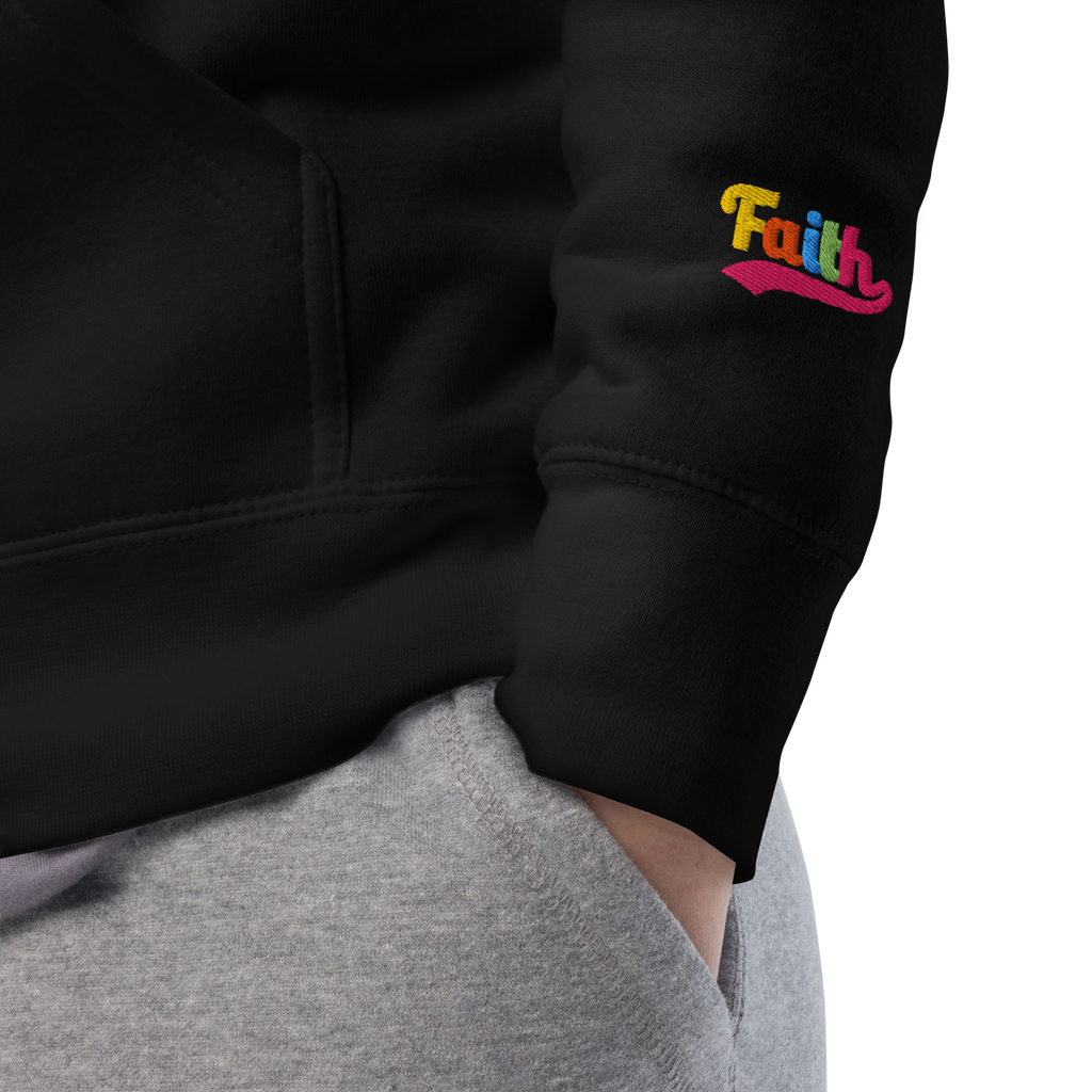 black hoodie with 'Faith' embroidered on the sleeve, worn by a person.