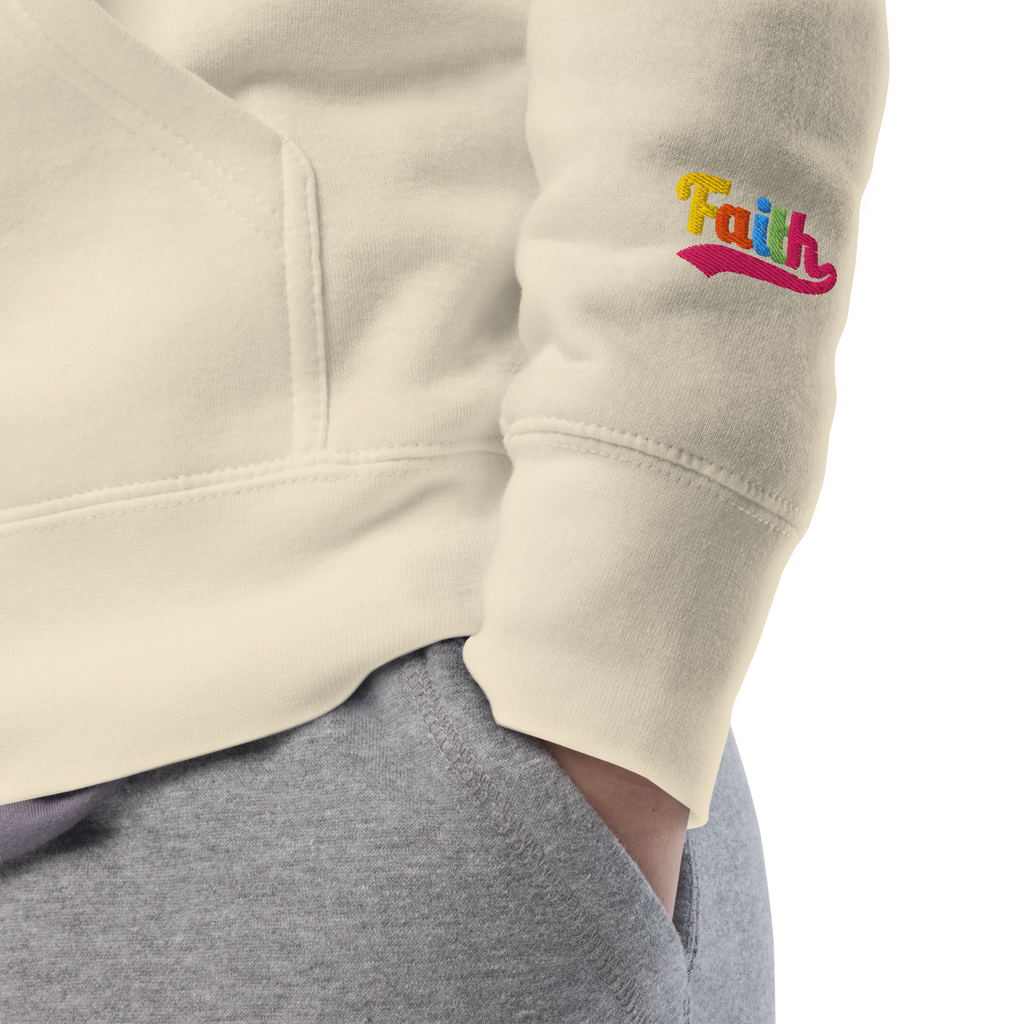 Beige sweatshirt sleeve with 'Faith' embroidered in colorful letters 