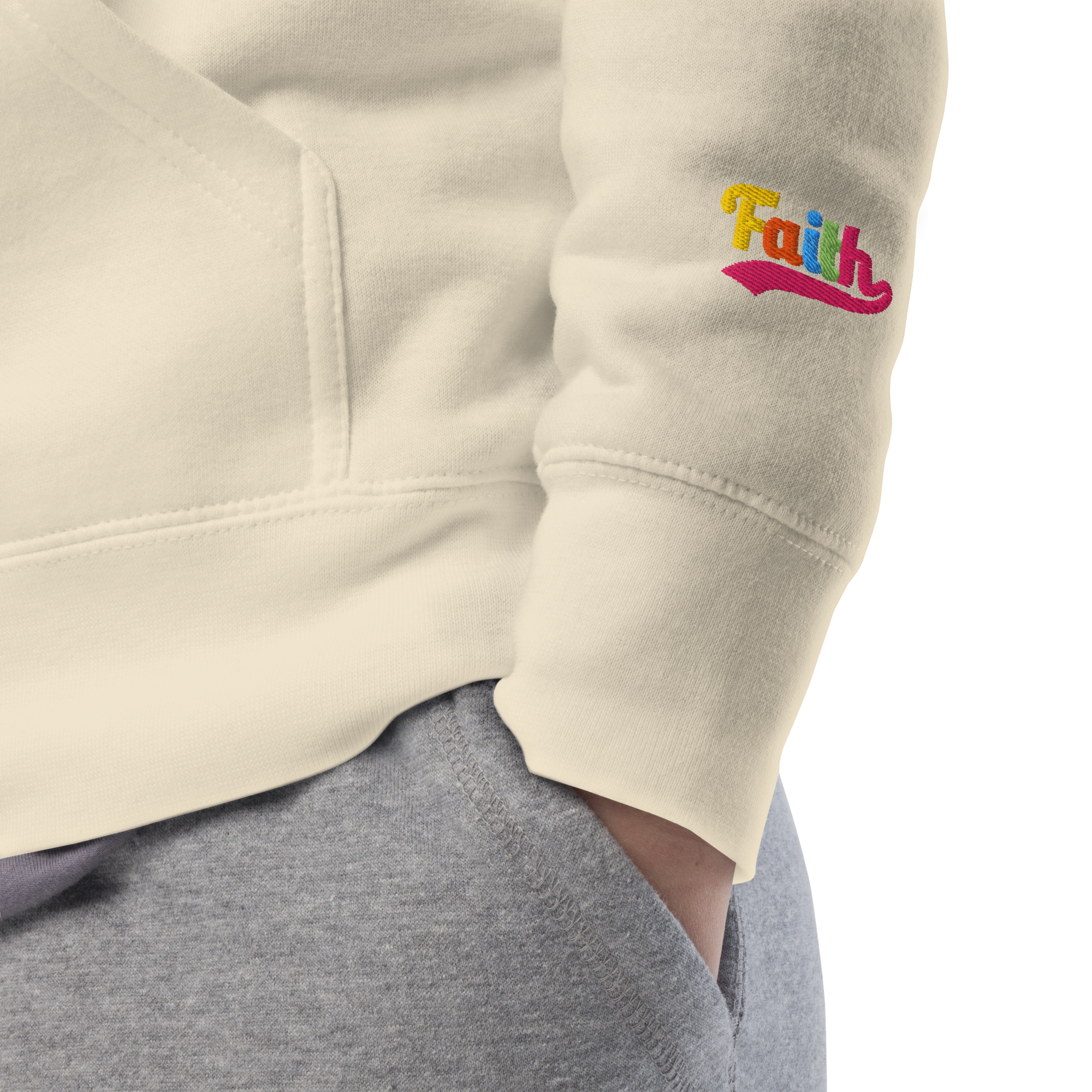 Beige sweatshirt sleeve with 'Faith' embroidered in colorful letters 