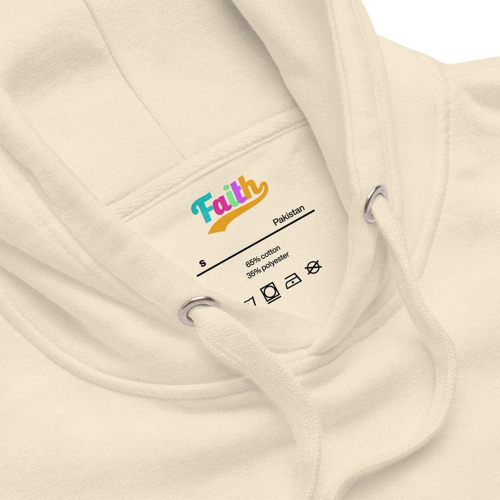 Close-up of a beige hoodie with a 'Faith' brand label 